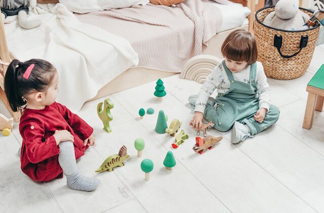 dzieci bawiące się drewnianymi zabawkami na podłodze